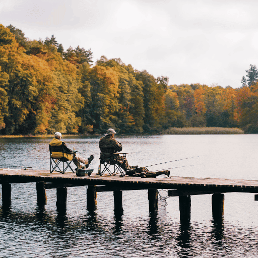 Two anglers fishing from a dock in the fall.