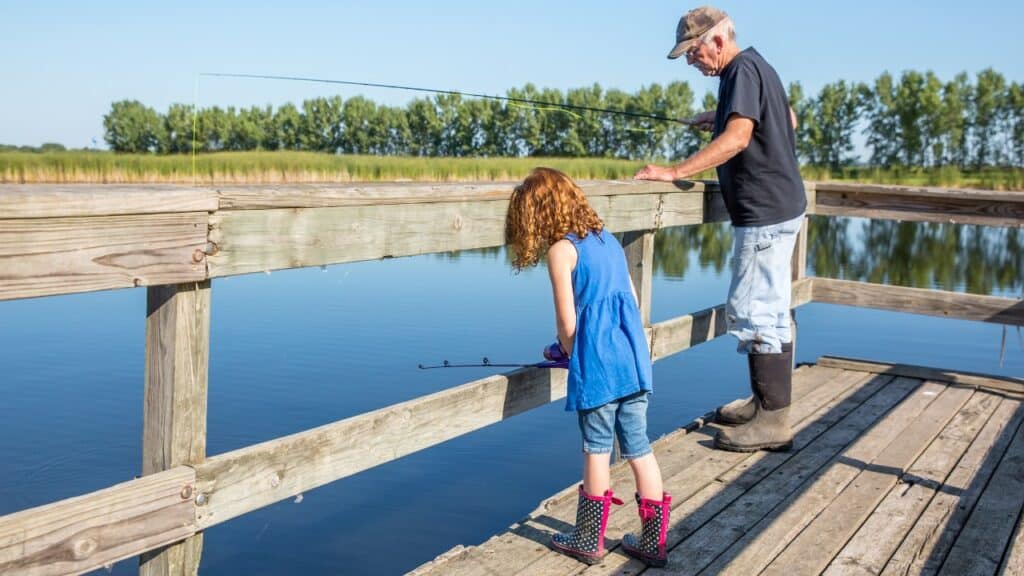 Older man and younger child fishing from a local fishing dock.